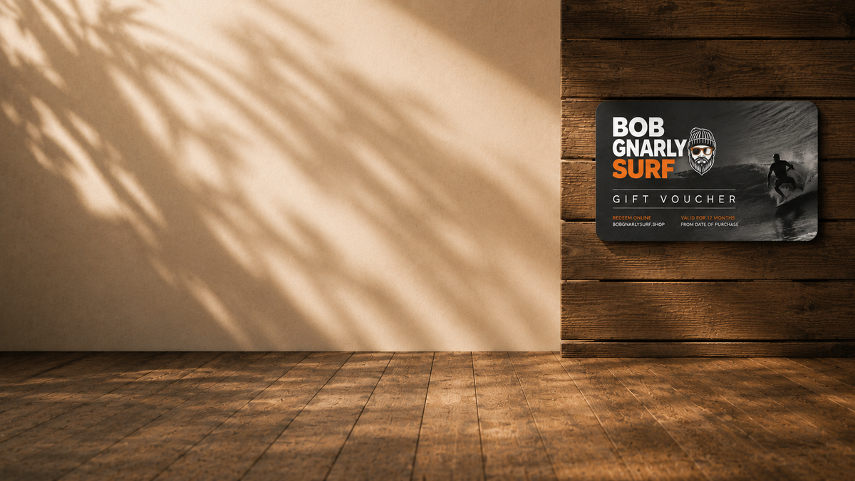 Bob Gnarly Surf gift card with yellow bow on black, skull logo with crossed surfboards on wooden background