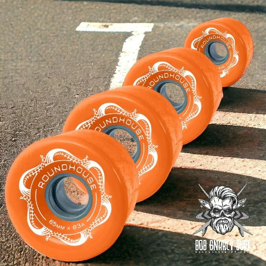 Orange Roundhouse Bob Gnarly Surf skateboard wheels 65mm x 83A on asphalt with shadow