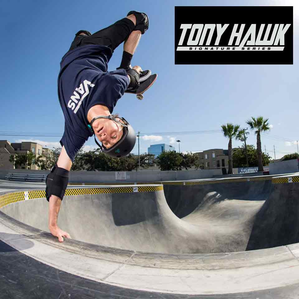 Skateboarder performing handstand trick in concrete skatepark bowl under clear sky, Tony Hawk logo